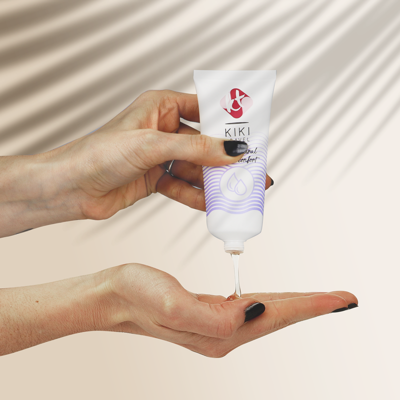 Hand holding a Kiki nail care product with a beige background