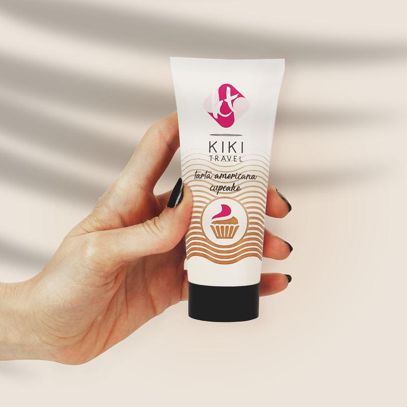 Hand holding a KIKI Travel product with a pink logo on a beige background