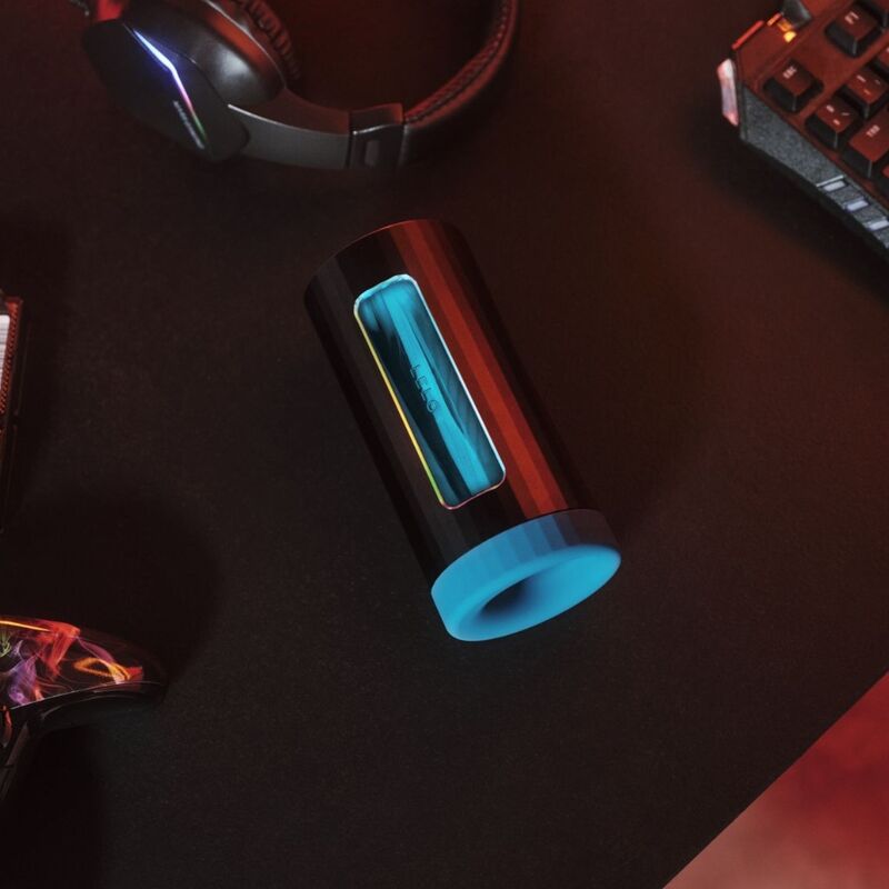 Glowing cylindrical object on a dark surface with gaming accessories in the background
